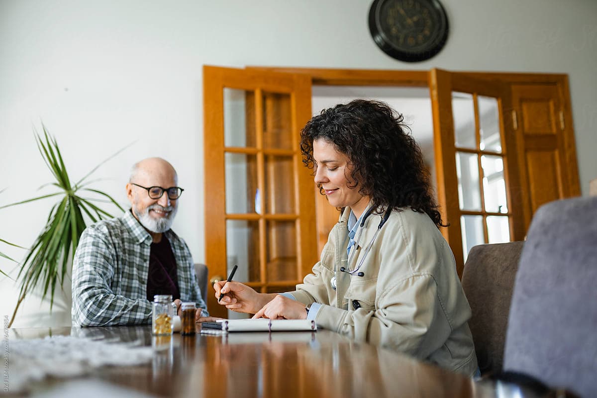 Clinician reviewing care notes with an older adult at home